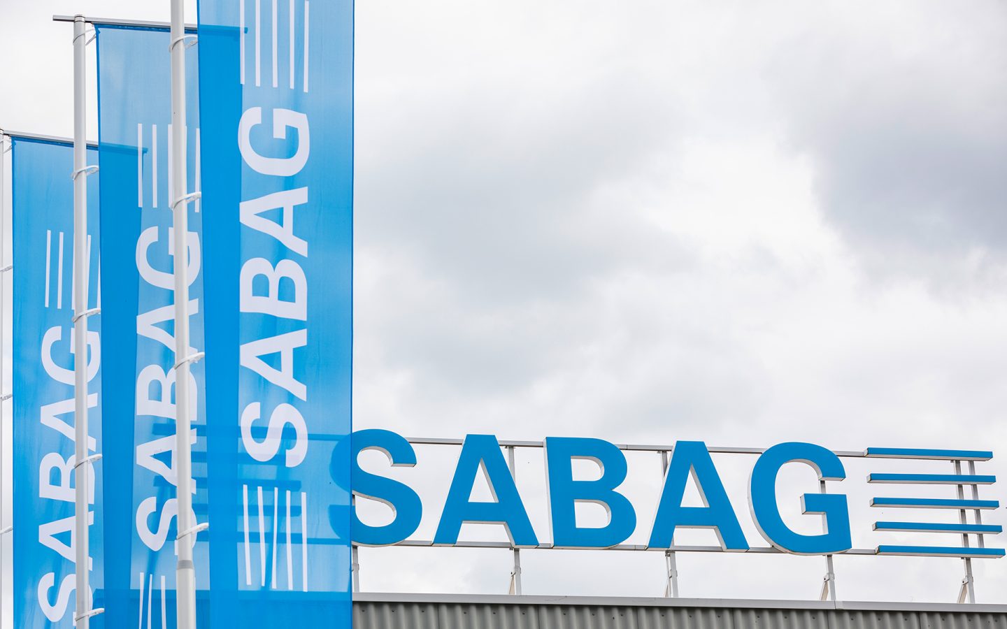 Bâtiment d'entreprise, lettrage et drapeaux de Sabag Holding AG