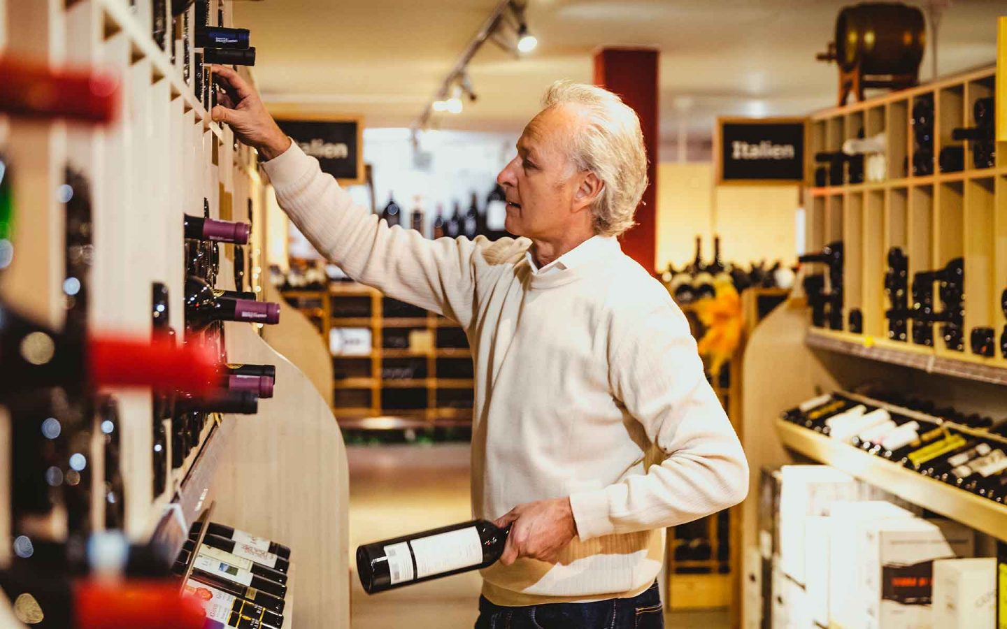 Roland Kaufmann seleziona le diverse bottiglie di vino.